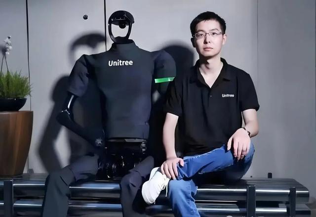 宇树科技创始人与其研发的人形机器人合影