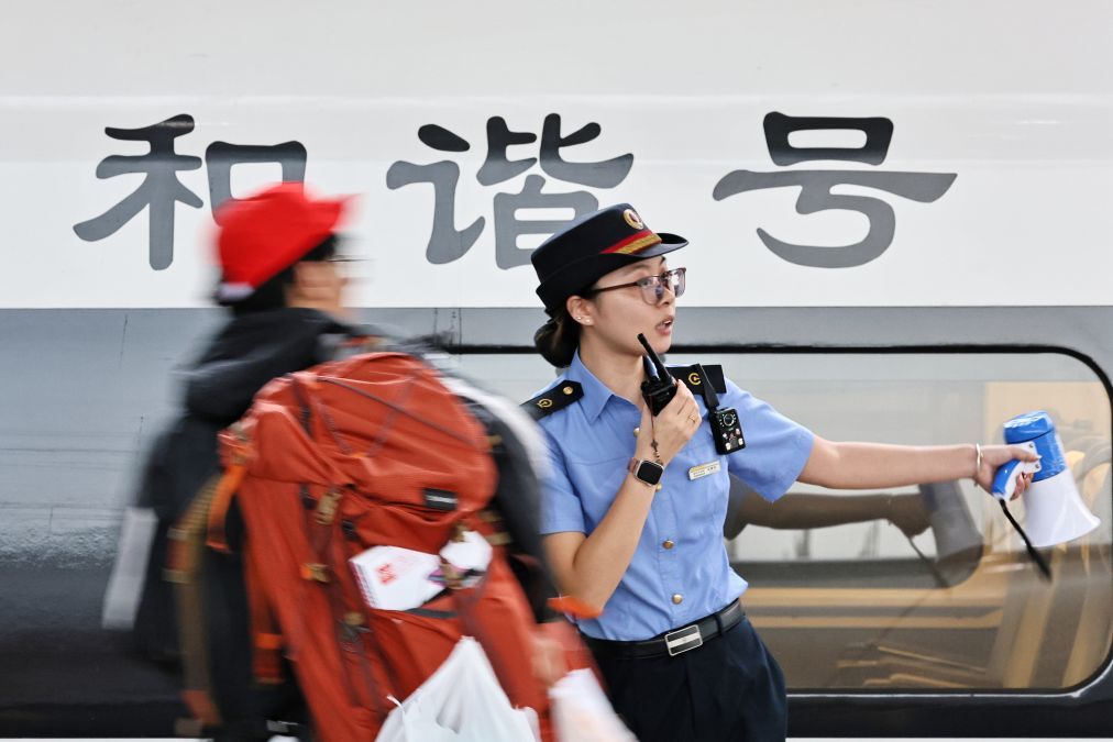 10月1日,在浙江嘉兴南站,工作人员在站台引导旅客有序乘车。新华社发(金鹏 摄)
