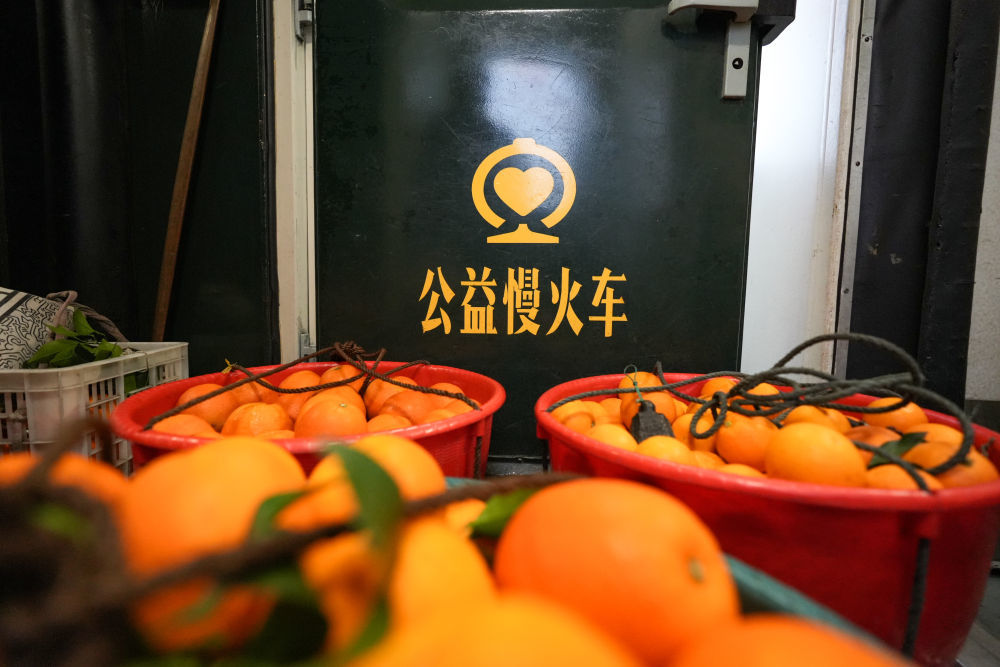 2026年2月12日，村民带的新鲜水果摆放在7272次公益“慢火车”车厢过道。