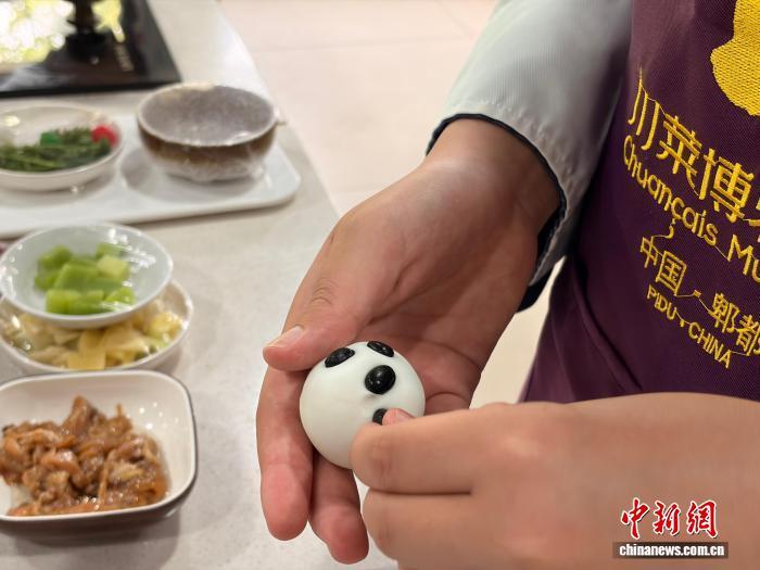 7月9日,四川成都,第三期美国华裔青少年“巴蜀文化品悟之旅”营员学做大熊猫汤圆。王利文 摄