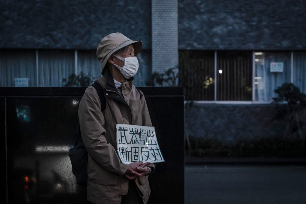 4月16日,在位于日本东京的首相官邸前,抗议者手持标语参加集会,反对解禁杀伤性武器出口。新华社记者贾浩成摄