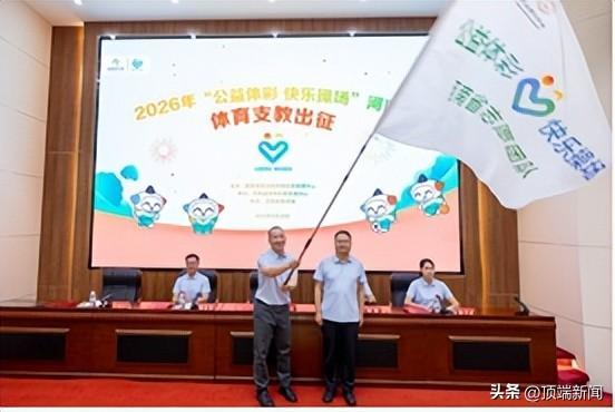 河南省体育彩票管理中心副主任王豪星(右)为河南体育学院体育教育系副主任代进军颁发支教旗