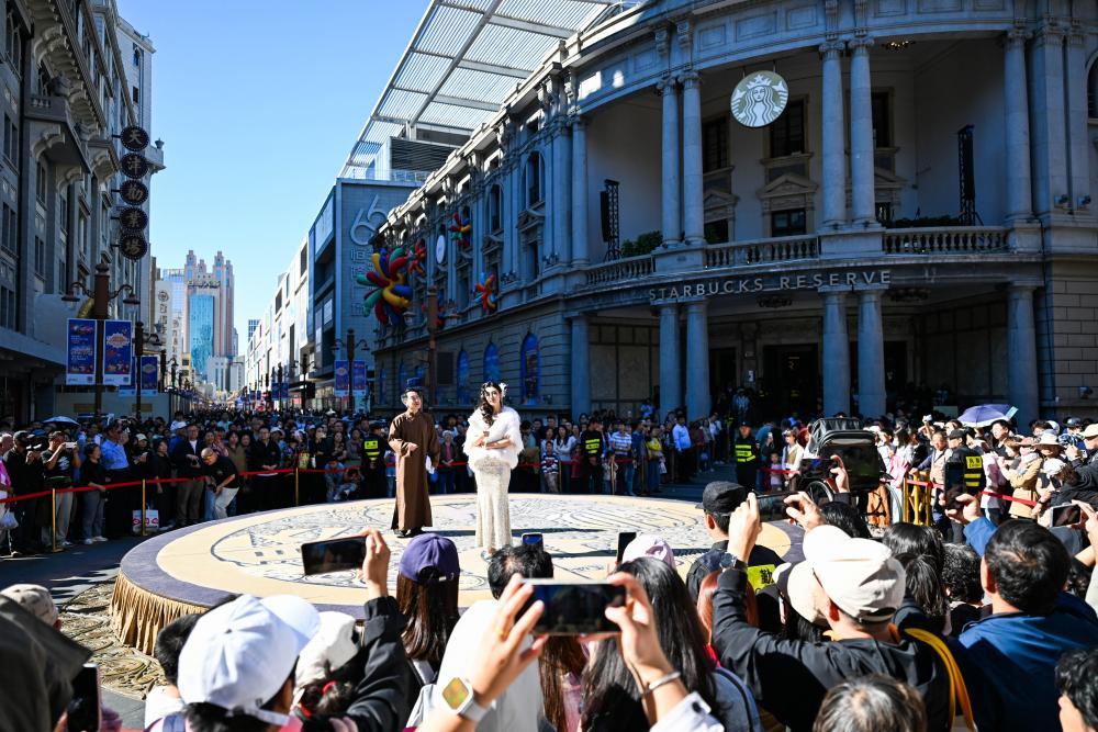 10月6日,游客在天津金街观看话剧《日出》片段表演。