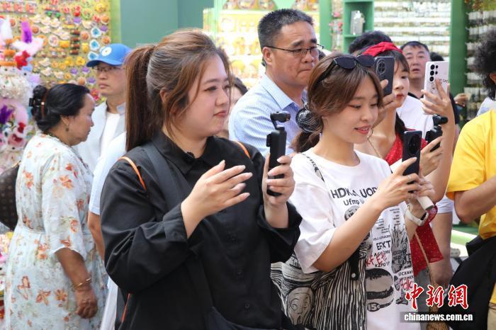 7月16日,台湾自媒体新疆行活动参访团在乌鲁木齐市的新疆国际大巴扎景区采访。 苟继鹏 摄