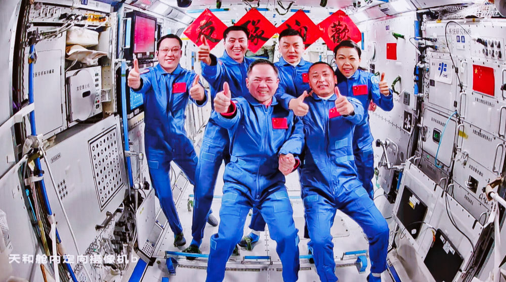 这是2026年5月25日在北京航天飞行控制中心飞控大厅拍摄的神舟二十一号航天员乘组和神舟二十三号航天员乘组拍摄“全家福”照片的实时画面。新华社记者 金立旺 摄