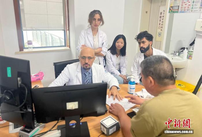 浙江大学医学院附属第四医院(下称浙大四院)全科医学科医生阿马尔(前排正中)在浙大四院门诊日常接诊。(受访者供图)