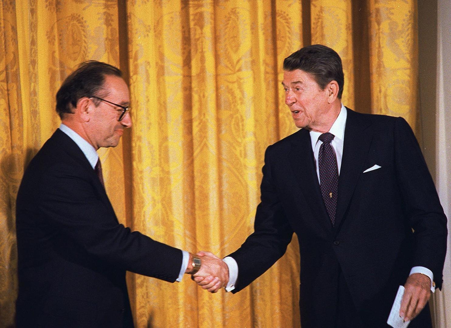 ▲ 当地时间1987年8月11日，美国华盛顿，时任美国总统里根在白宫举行的仪式上祝贺格林斯潘宣誓就任美国联邦储备委员会主席（图据视觉中国）