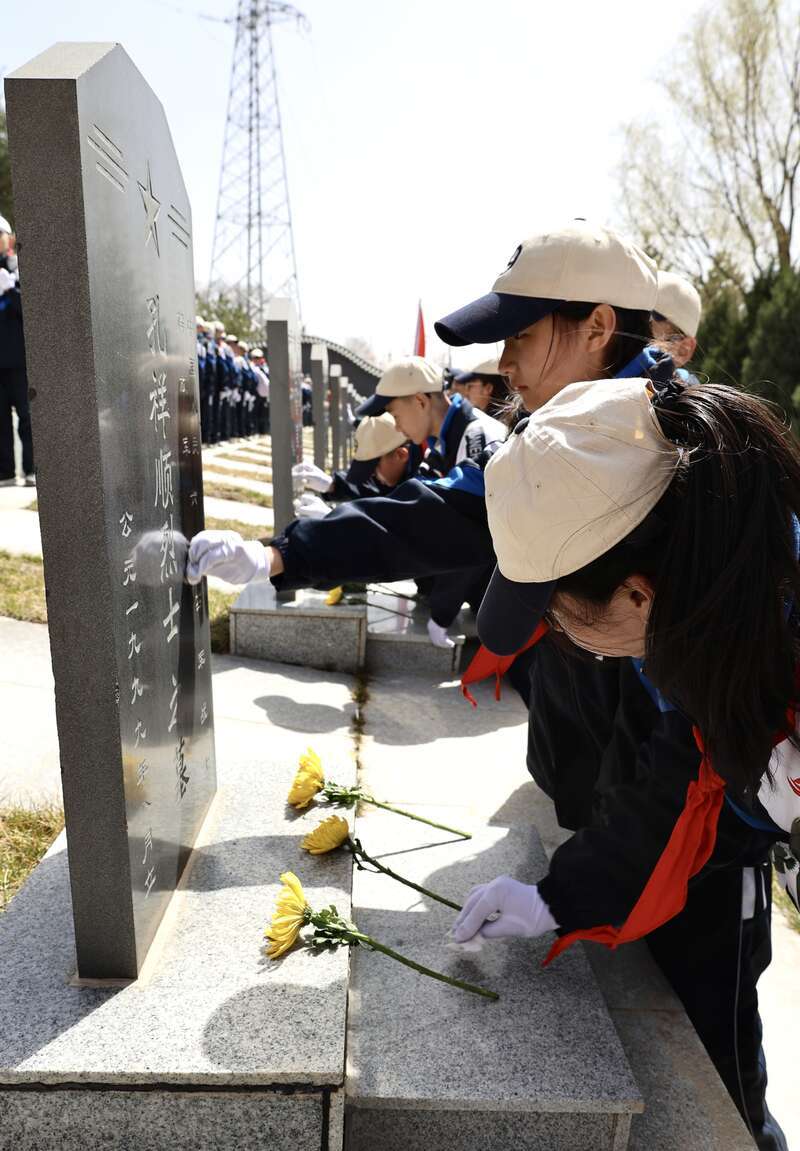 4月3日上午11时许,位于宁夏固原市彭阳县古城镇的任山河烈士陵园内,学生们向烈士墓碑敬献花朵,并擦拭墓碑。中青报·中青网记者 焦敏龙/摄