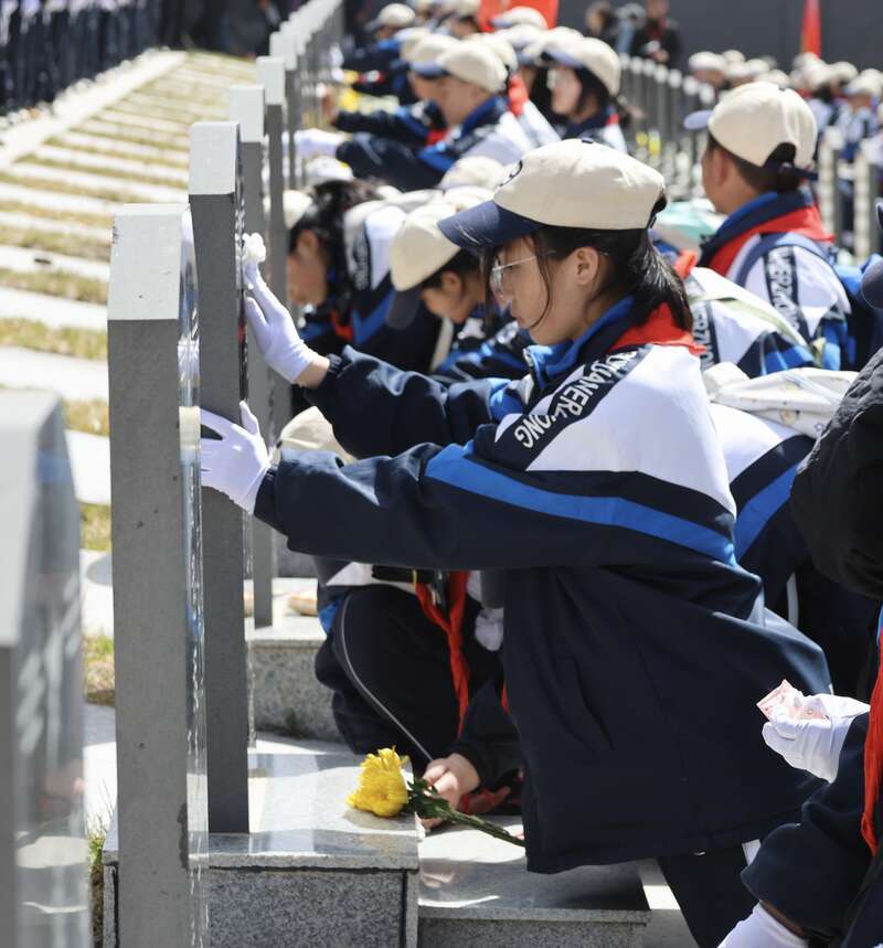 4月3日上午11时许,位于宁夏固原市彭阳县古城镇的任山河烈士陵园内,学生们轻轻擦拭烈士墓碑。中青报·中青网记者 焦敏龙/摄