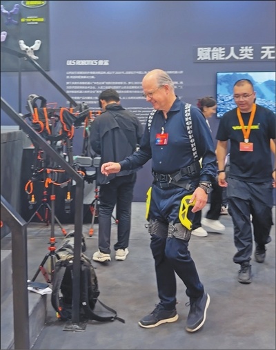 参加会议的企业家体验外骨骼机器人。本报记者 王崟欣摄