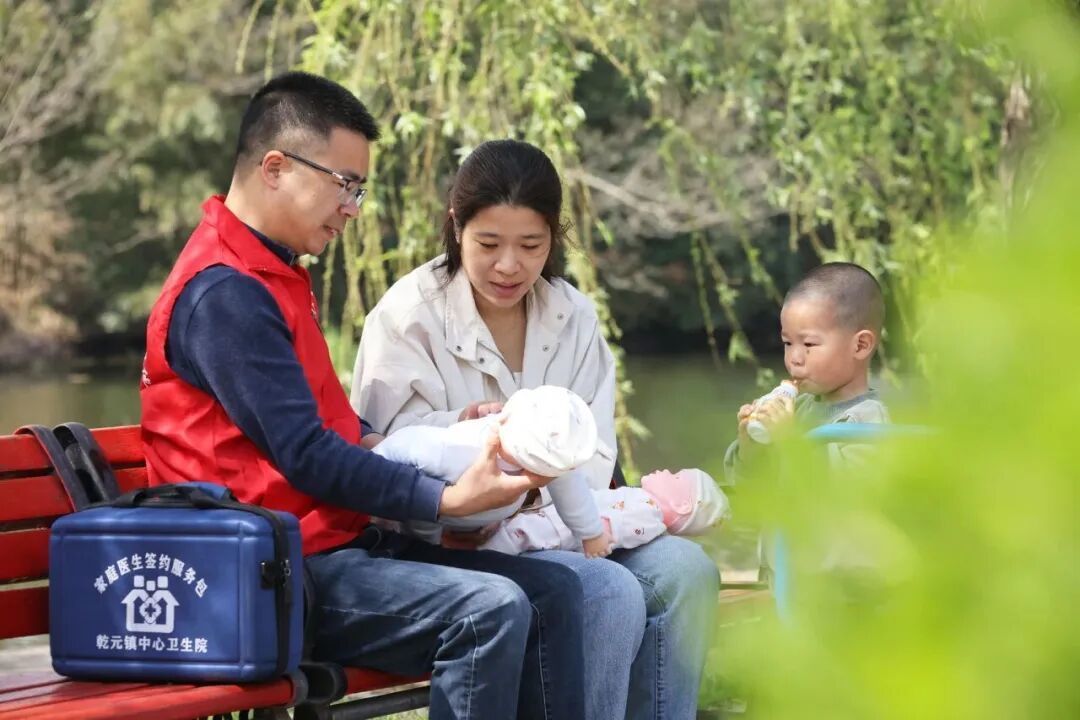 2025年4月7日,浙江省湖州市德清县乾元镇中心卫生院家庭医生、浙江省基层名中医王红武(左)在联星中心村体育休闲公园,指导宝妈进行婴幼儿中医推拿按摩保健/新华社发(倪立芳摄)