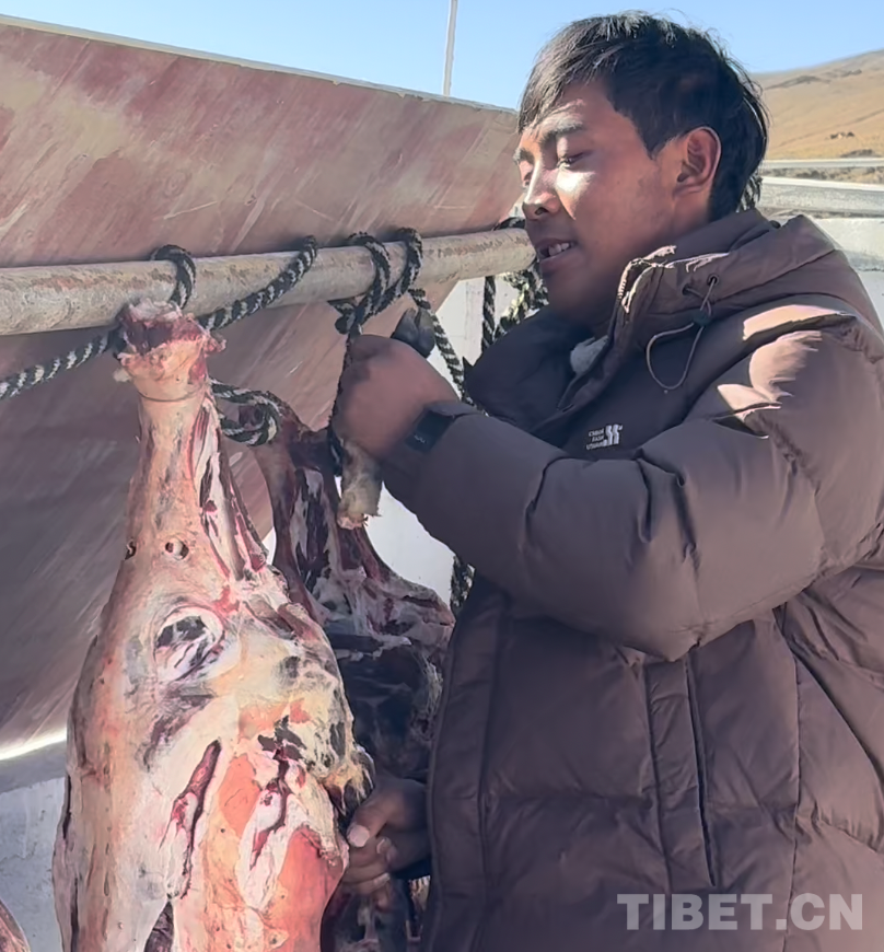 图为定日县长所乡古荣村村民罗布正在新房前晾晒风干羊肉 摄影：旦曲