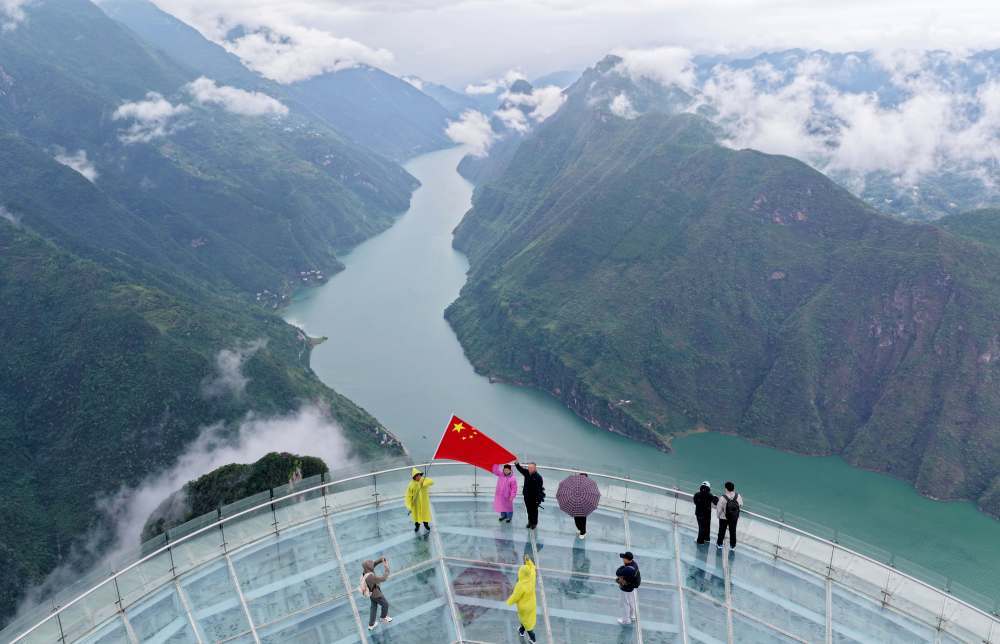 10月1日，在湖北省恩施土家族苗族自治州巴东县巫峡口景区，游客在玻璃观景平台上合影留念。新华社发（焦国斌 摄）