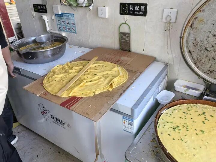 图为某外卖门店后厨的场景,煎饼直接放置在纸壳上。新华每日电讯记者牛少杰 摄