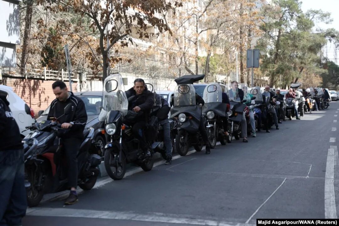 People wait in line outside a fuel station in Tehran. Iran has been plunged into a 