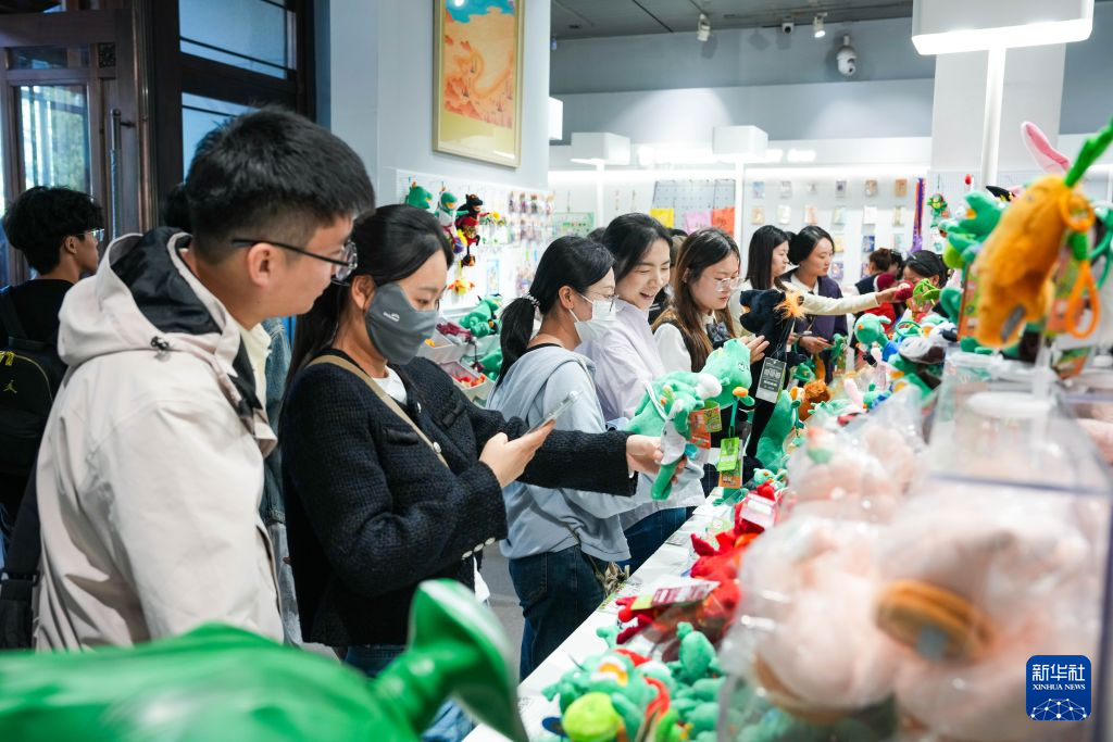 10月4日,游客在甘肃省博物馆文创商店挑选“马踏飞燕”玩偶。新华社记者 郎兵兵 摄