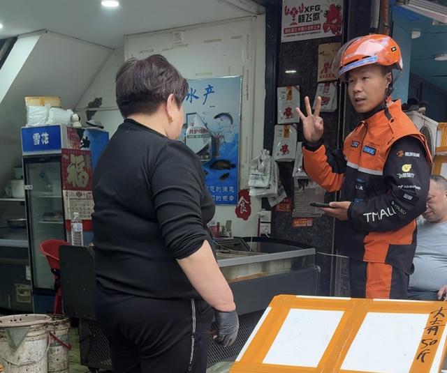 李军向水产店老板比“OK”的手势