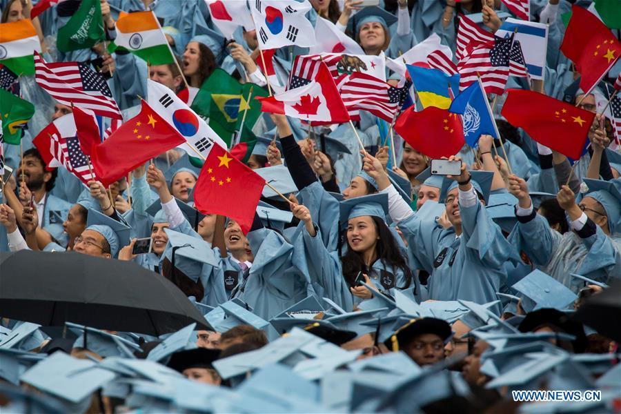2018年，美国哥伦比亚大学国际与公共事务学院毕业生在毕业典礼上挥舞各国国旗 新华网