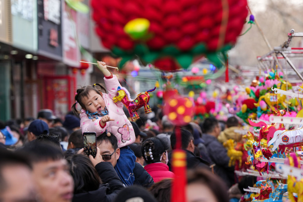 2月17日,一名小朋友和家人在南京夫子庙灯市游览。新华社记者 李博 摄