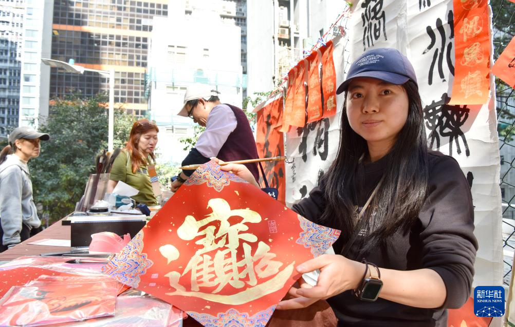 2月13日,在香港楼梯街,萧颖妍展示挥春作品。新华社记者 陈铎 摄