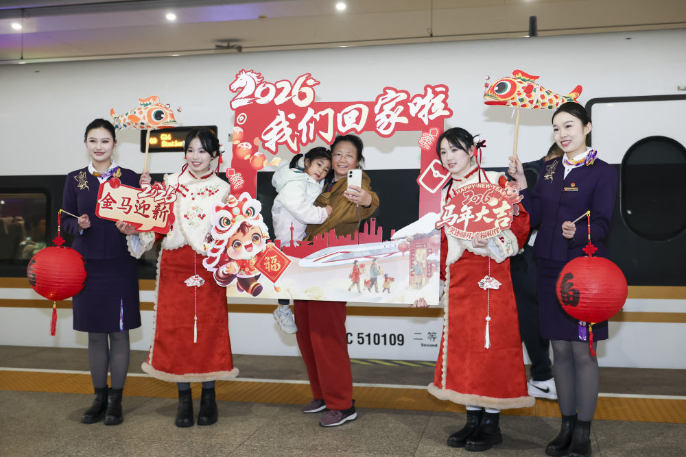 2月2日,在上海虹桥火车站,旅客和铁路上海客运段乘务员在G14列车外打卡合影。新华社记者 王翔 摄