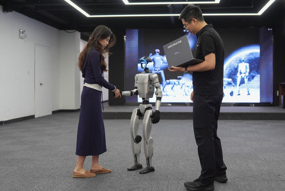 2025年4月23日，在机器人公司杭州宇树科技展厅内，宇树人形机器人G1展示握手动作。新华社记者 黄宗治 摄