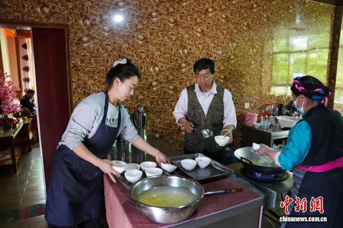 图为卓玛拉姆与家人为食客制作加加面。 中新网记者 刘冉阳 摄