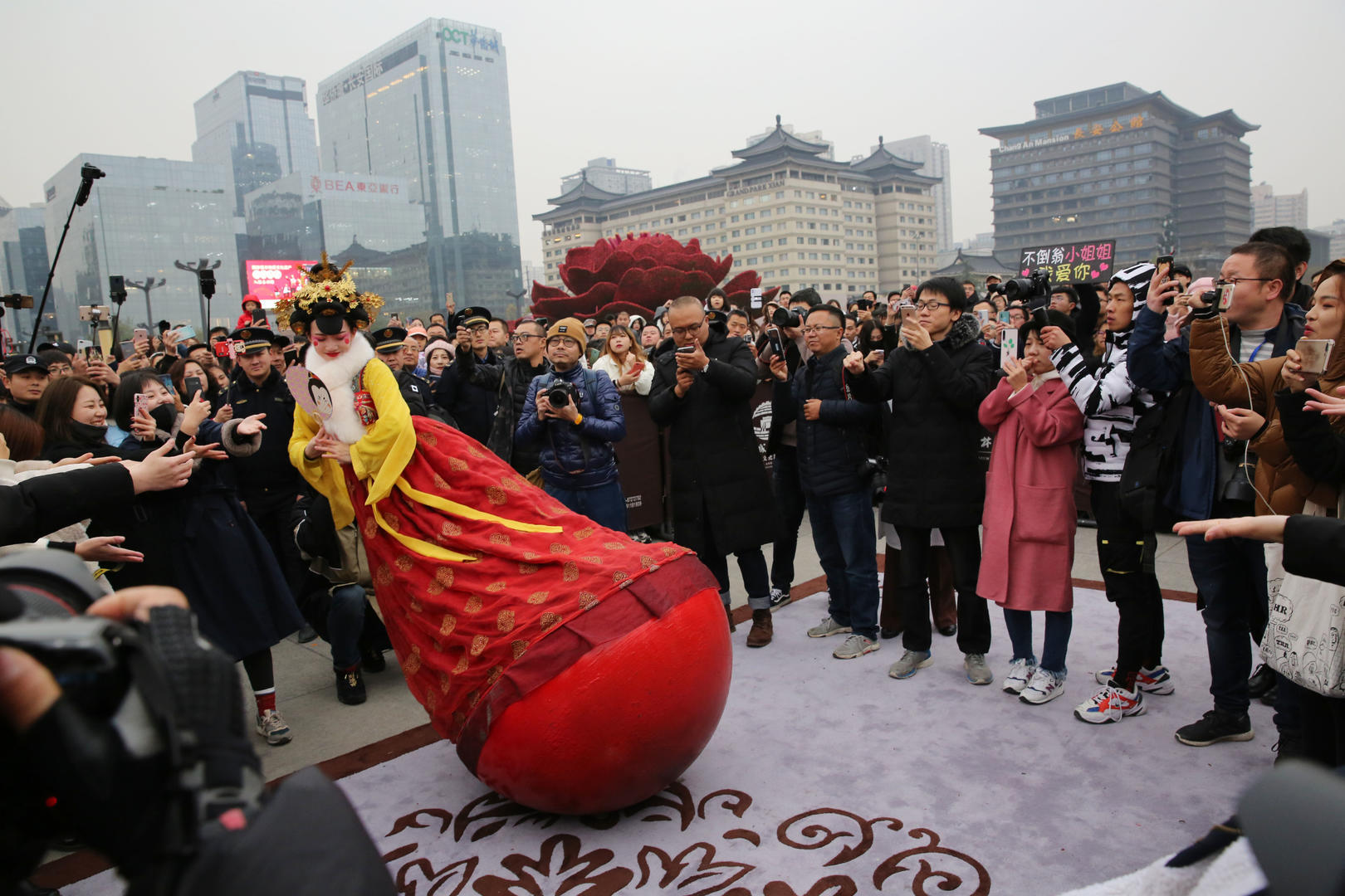 ▲2019年11月29日下午,“不倒翁小姐姐”走出西安大唐不夜城,开启她的巡游模式,首站巡游,她来到西安城墙,在永宁门广场和唐朝仕女翩翩起舞,市民和游客争相和她牵手 图据IC photo