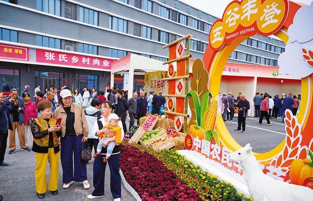 市民在丰收节“五谷丰登”造型景观前打卡拍照。谢克强 赵志华摄