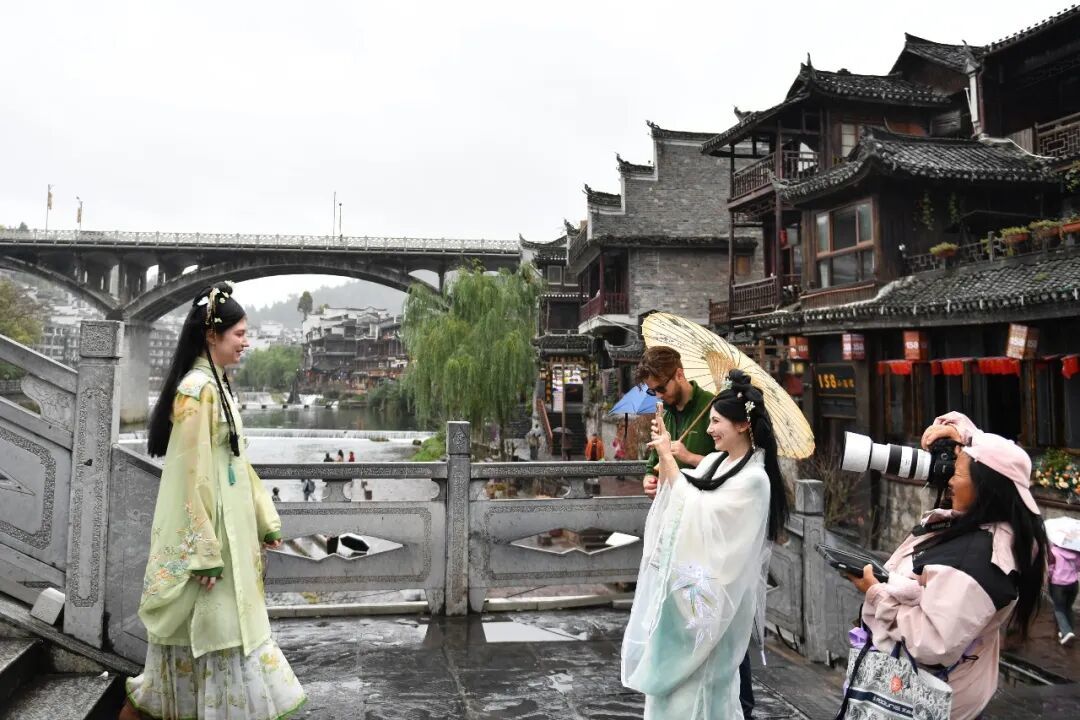 外国游客身着“中国风”服装在凤凰古城拍照/新华社记者 陈振海 摄