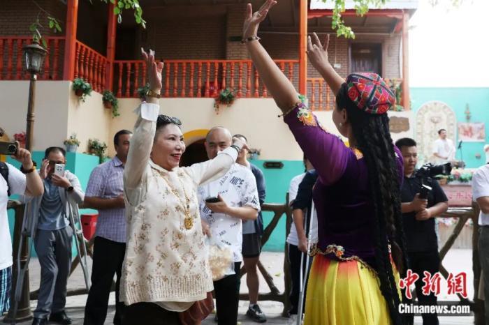 2025年9月10日,新疆吐鲁番坎儿井民俗园景区,游客与表演者共舞。中新社记者 王紫儒 摄