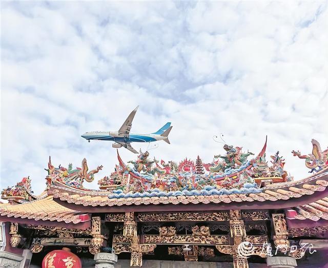 飞机低空掠过闽南古厝。（本报记者 杨霞瑜 摄）