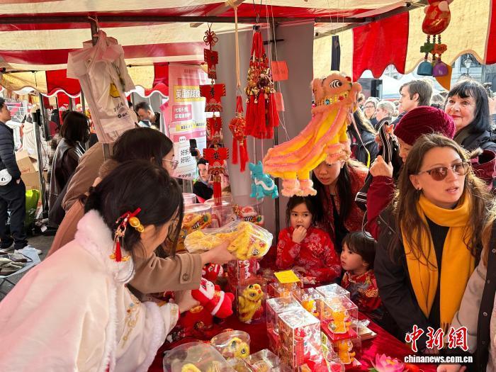 当地时间2月22日，由英国伦敦华埠商会主办的中国新年庆典在特拉法加广场举行。图为当地顾客争相购买新春纪念品。　中新社记者 欧阳开宇 摄