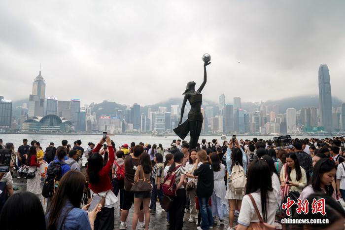 4月4日,正值内地清明假期首日,不少游客在香港尖沙咀星光大道游览。 中新社记者 张祥毅 摄