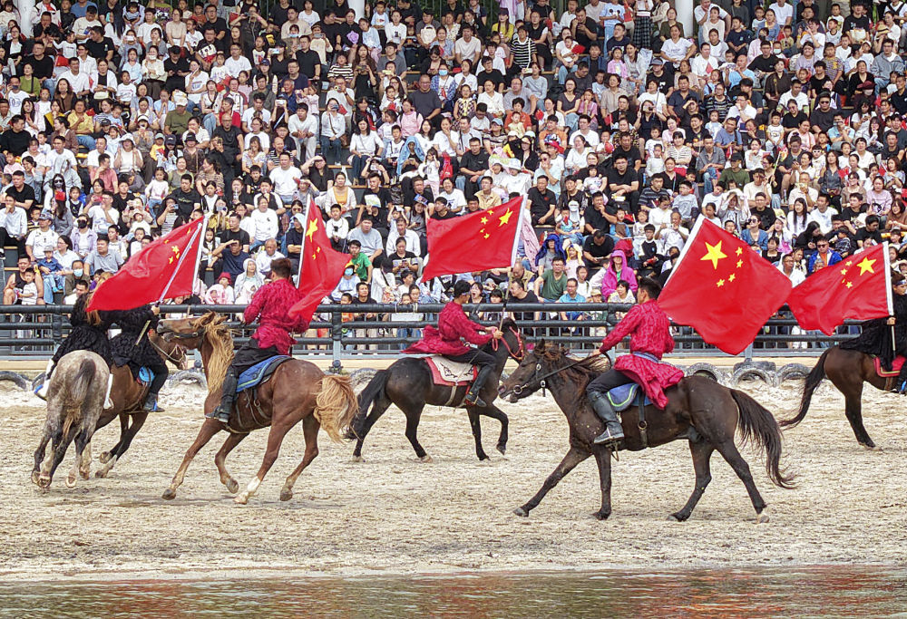 10月1日，游客在江苏南通森迪旅游度假区观看马术编队表演。新华社发（许丛军摄）