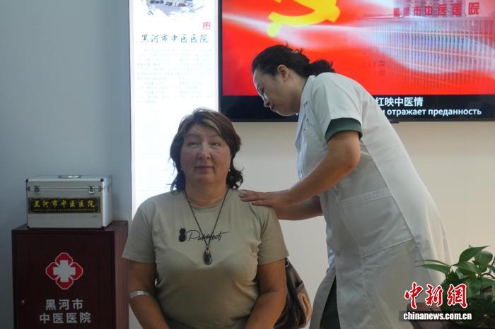 免签政策加持下，大批俄罗斯游客从黑龙江黑河过境，来到中国旅游。图为6月21日，一名俄罗斯游客在黑河口岸体验中医推拿。　江宇阳 摄