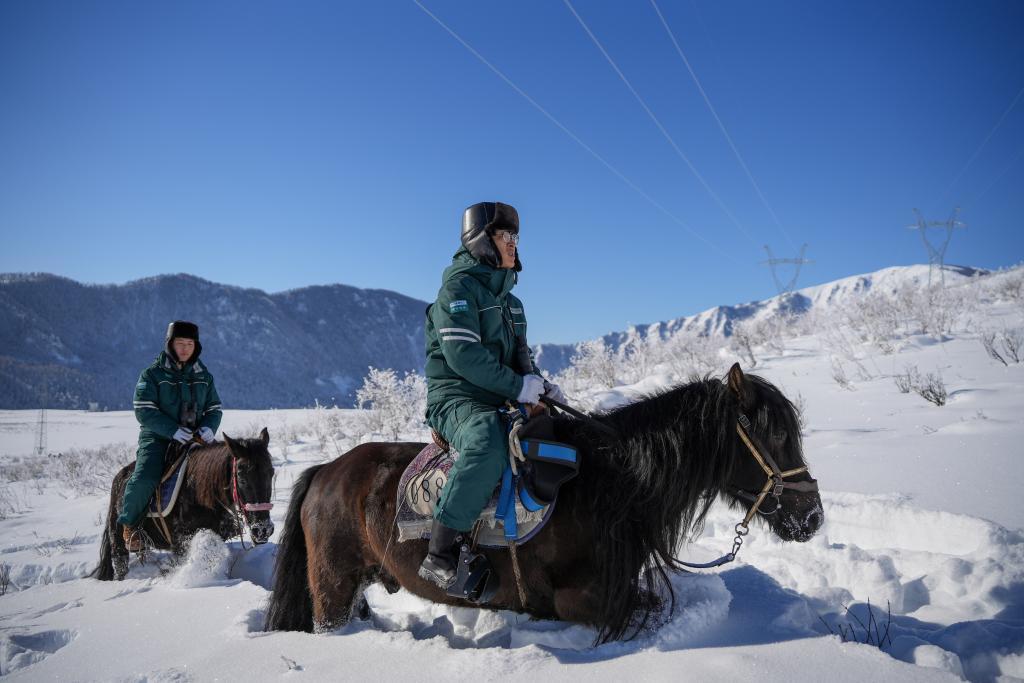 禾木110千伏输电线路巡线工人闫向红、马铭在骑马巡线。新华社记者徐宏岩 摄