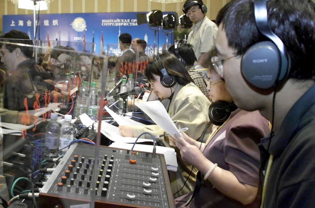 2001年6月15日，六国元首在上海共同签署《“上海合作组织”成立宣言》和《打击恐怖主义、分裂主义和极端主义上海公约》，工作人员在签字仪式上进行同声翻译。