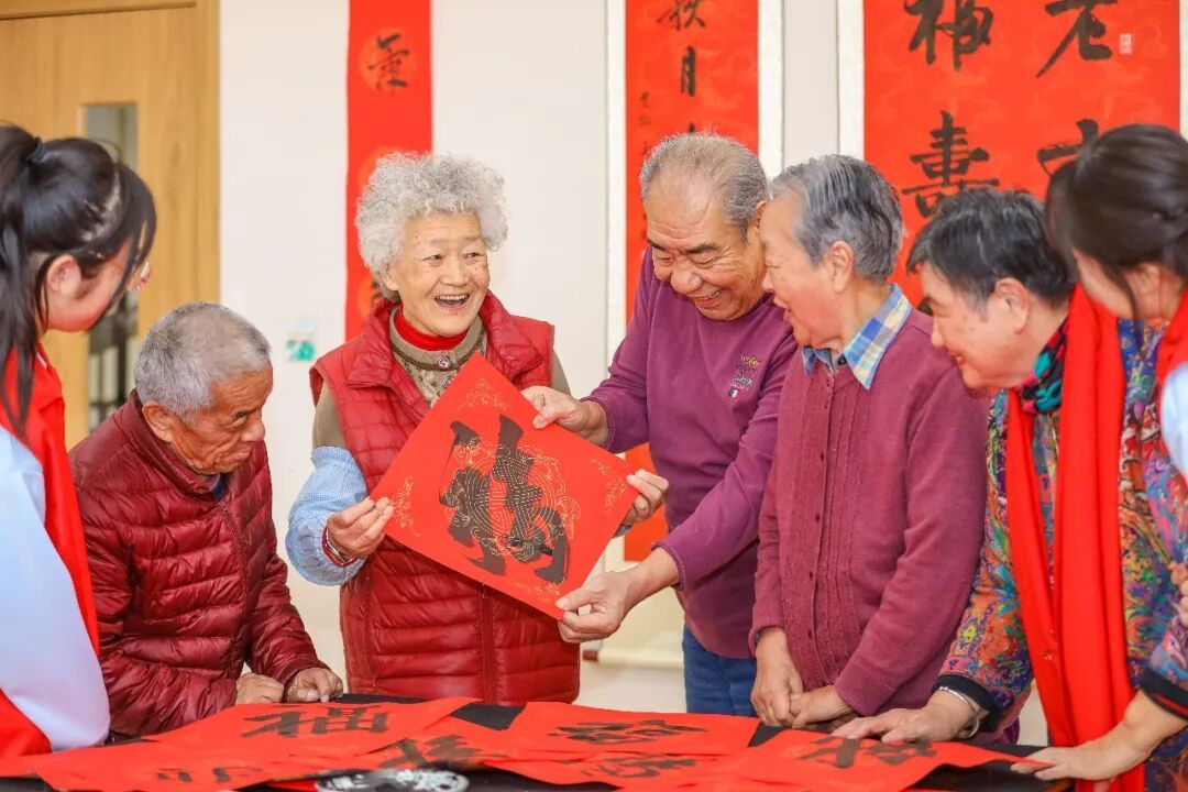 2月10日,在山东省青岛市李沧区颐福养老院开展的“暖意迎新春 温情伴朝夕”主题活动中,老年人展示自己写的“福”字。张鹰摄(中经视觉)