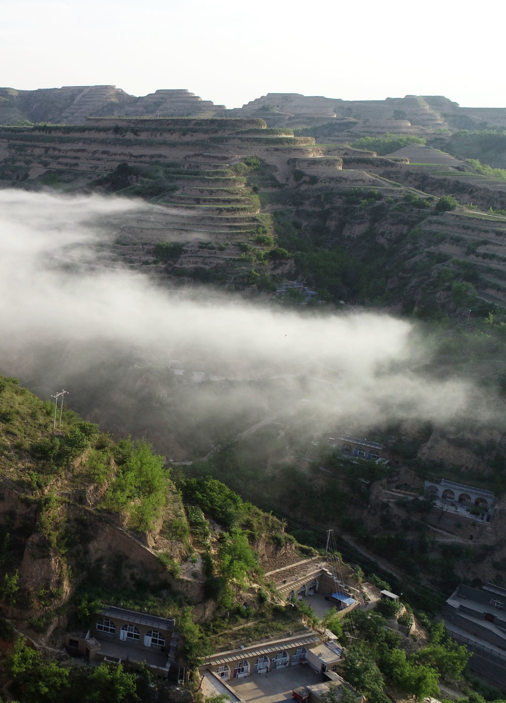 晨雾中的绥德县郝家桥村（2022年6月17日摄，无人机照片）。 新华社记者 陈昌奇 摄