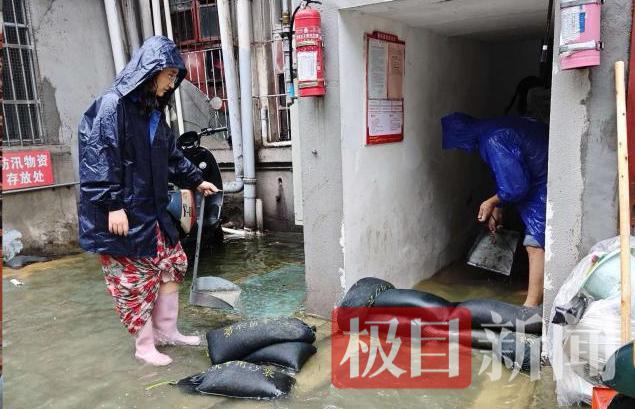 该所工作人员冒雨在楼栋口垒砌沙袋（通讯员 供图）