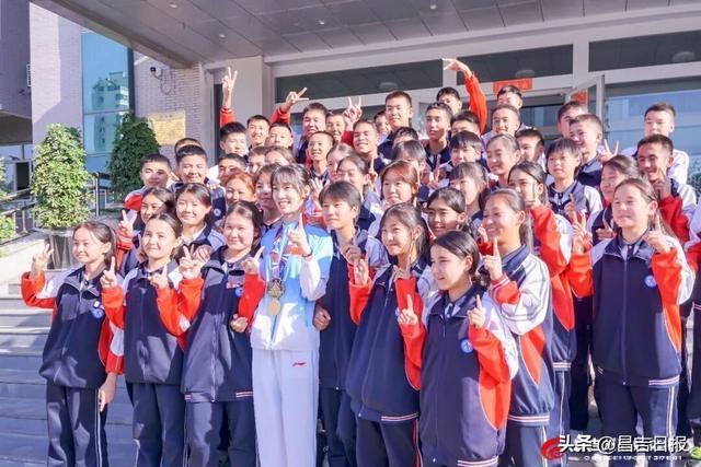 马静月在昌吉市第七中学与学生合影。通讯员杨斌 摄
