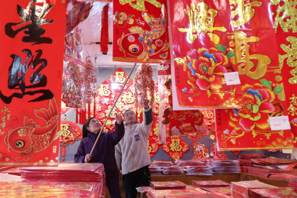 ⬆️1月25日,顾客在河南省焦作市温县赵堡镇赵堡村年货市场选购春联、年画。新华社发(徐宏星摄)