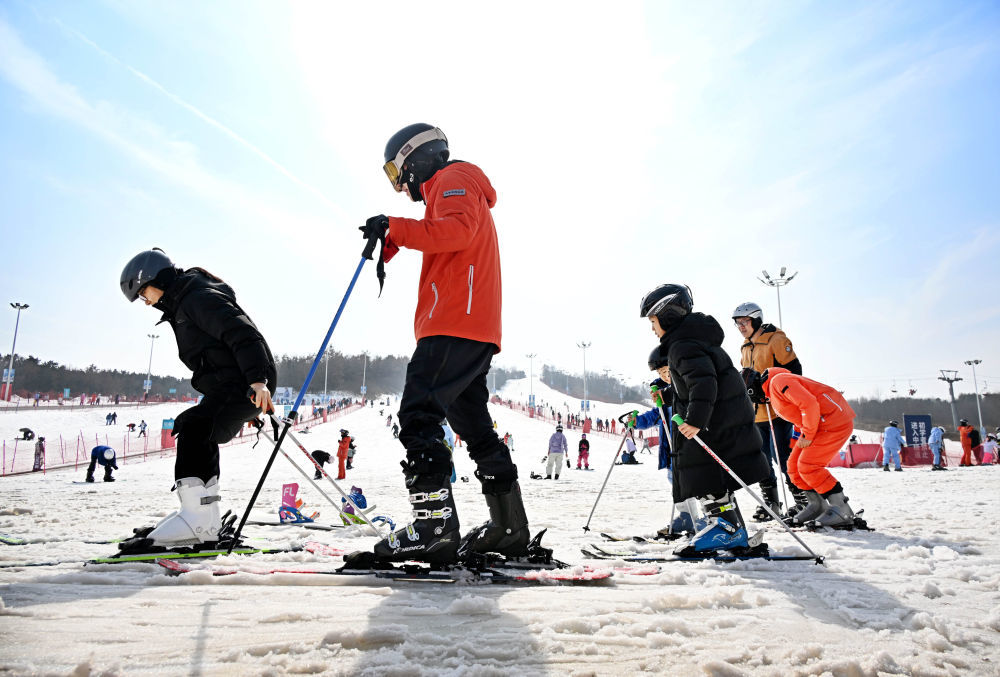 2月13日,游客在青岛西海岸新区融创藏马山滑雪场学习滑雪。当地以“冰雪+文化”“冰雪+旅游”聚人气、促消费、添年味。新华社记者 李紫恒 摄