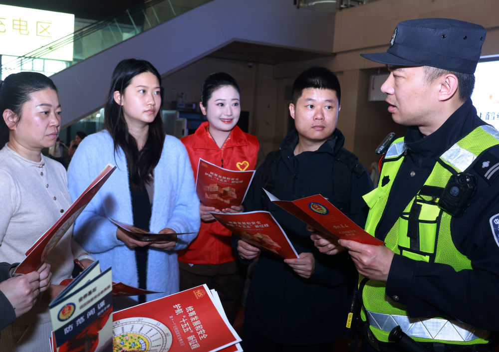 4月13日，武汉铁路公安处民警、志愿者在湖北省汉口站向旅客宣讲防范化解危害国家安全行为的知识。新华社发（赵军 摄）
