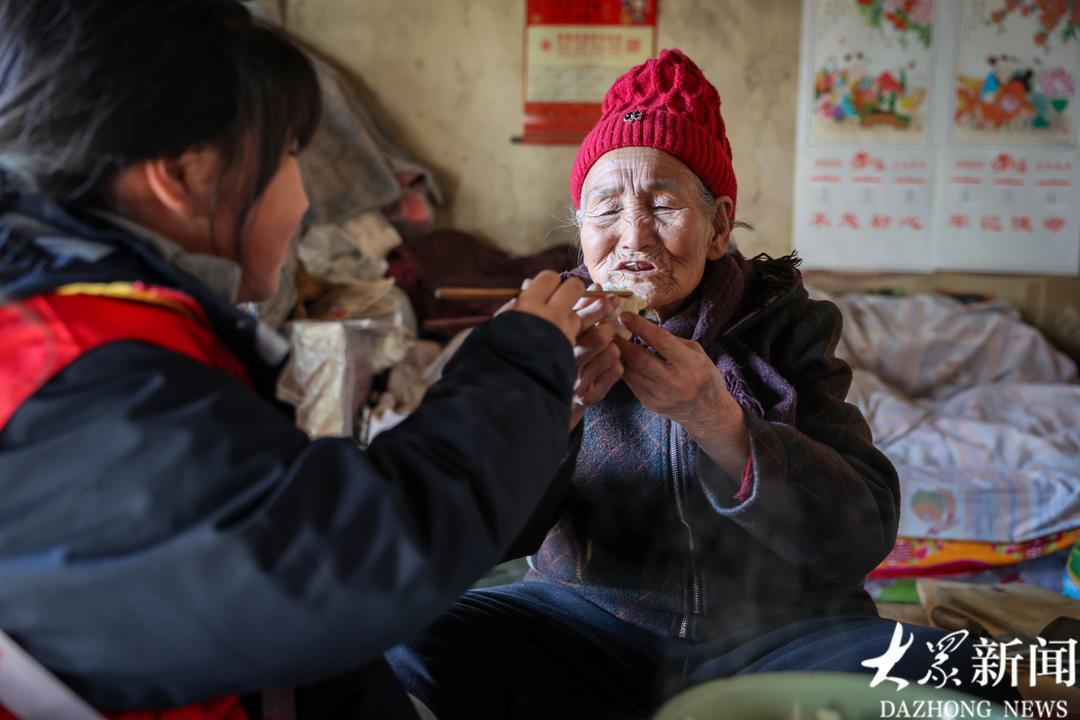 小志愿者刘梓瑜陪李元花吃饺子“过小年”。