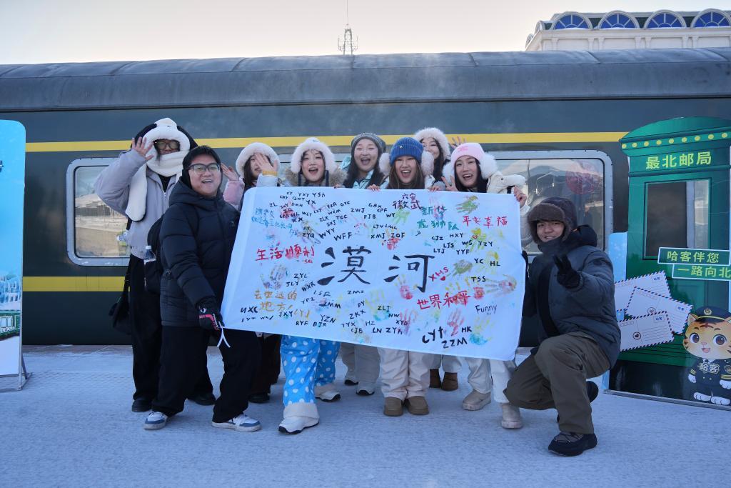 2026年1月27日,游客在漠河站展示手绘画作。冰窗花、林海雪原……连日来,坐上由哈尔滨站开往漠河站的K7039次“雪国列车”,来自天南海北的游客把冬日限定美景尽收眼底,沉浸式体验北国风光。新华社记者 王祚 摄