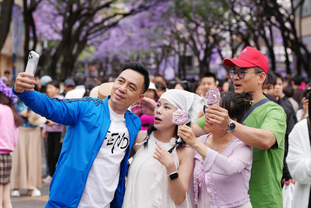 5月2日，在云南省昆明市教场中路，来自越南的游客手拿昆明文创雪糕合影。新华社发（郝亚鑫 摄）