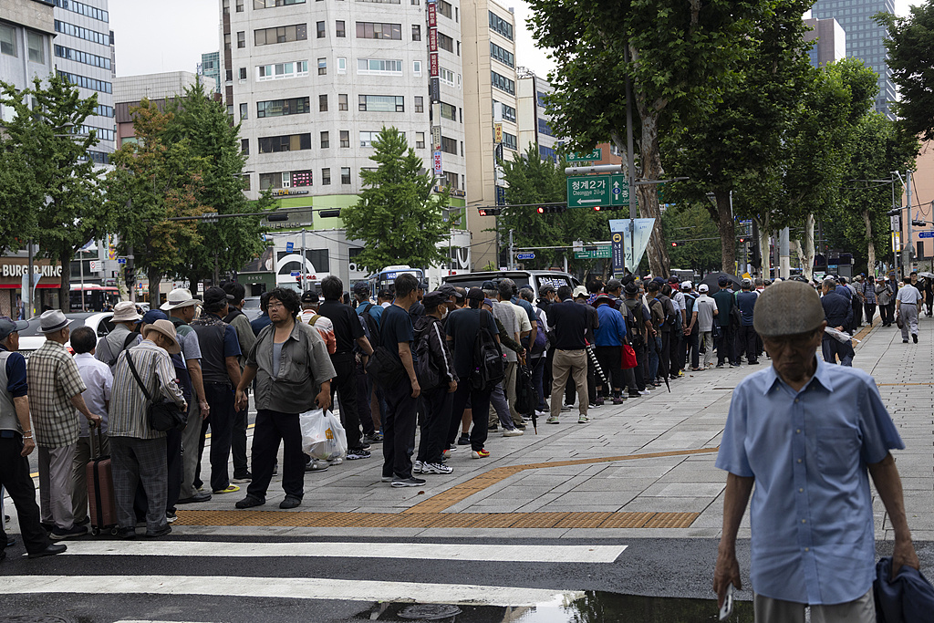 当地时间2026年7月10日,韩国首尔,老年人在塔谷公园外排队领取免费餐食。视觉中国 资料图