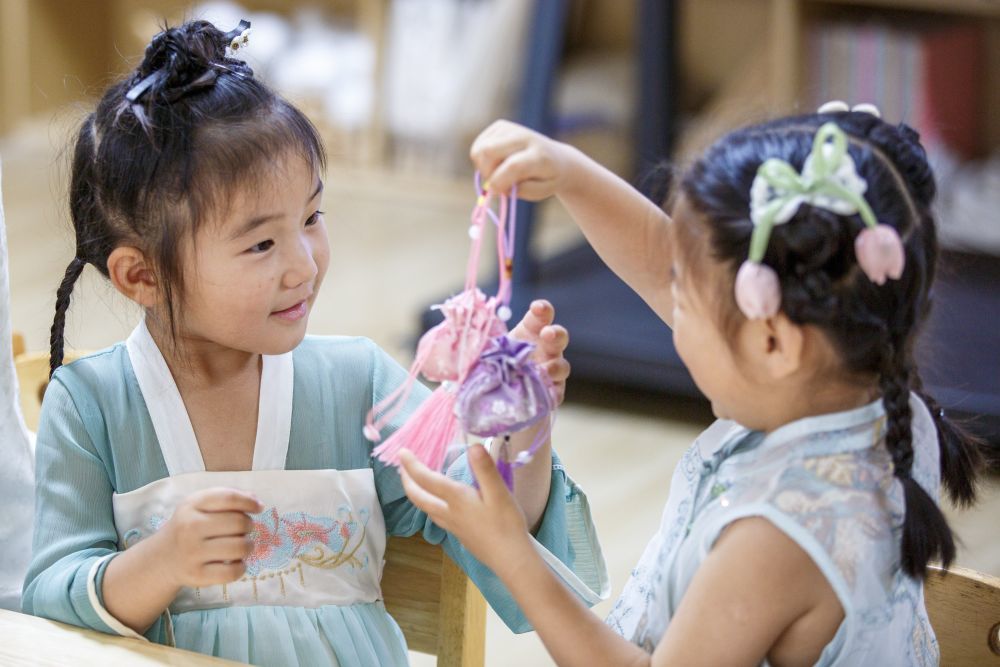 6月18日,河南省商丘市睢县古襄路幼儿园的小朋友在制作艾草香包。新华社发(徐泽源 摄)